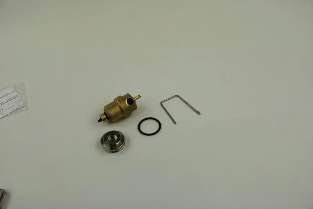 BOSCH Entlüfter-Set bestehend aus einer Metallkomponente mit Anschlüssen, einem O-Ring, einer Halterung und einer weiteren Metallteile; auf weißem Untergrund angeordnet.